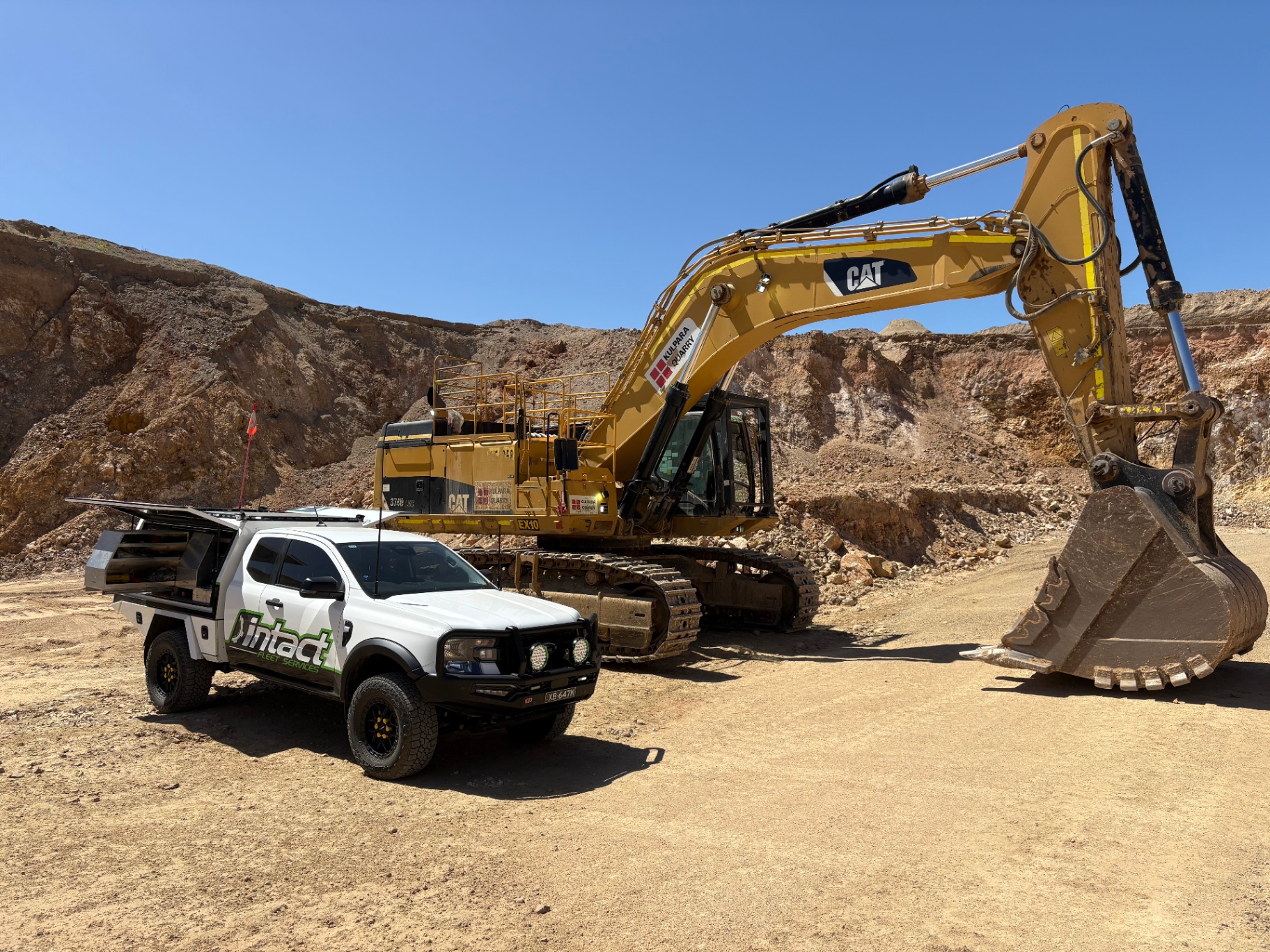 Intact Fleet Services ute on site with CAT excavator at a quarry